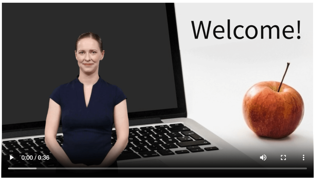 AI avatar video featuring a virtual teacher welcoming students, displayed on a screen with a laptop and apple, ideal for classroom engagement.